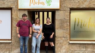 Patrick, Anais y Paloma posan en la puerta de su próximo negocio en Barruelo de Santullán