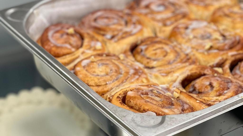 Una bandeja repleta de cinnamon rolls.