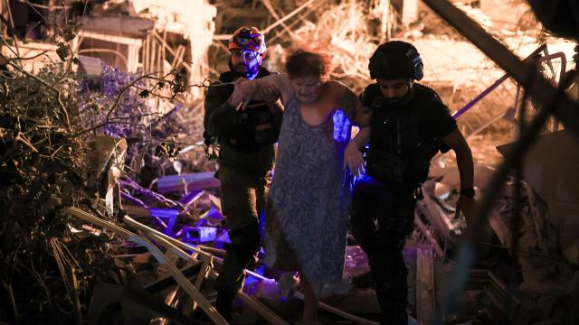 El personal de rescate ayuda a una mujer herida, en el centro de Israel.