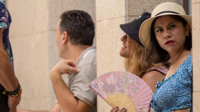 Una turista se refresca del calor de Toledo con un abanico.