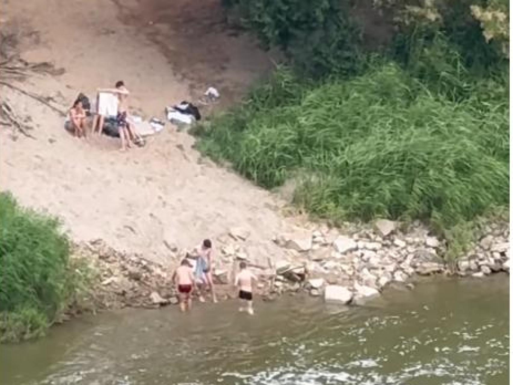 Un grupo de jóvenes se bañan en el Tajo.