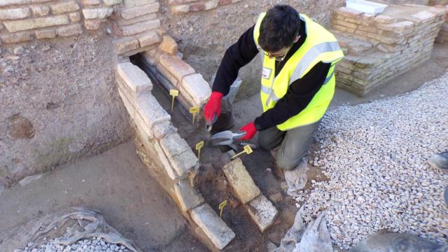 Un investigador toma muestras de las canalizaciones del yacimiento de San Esteban (Murcia) para enviarlas a analizar en laboratorio.