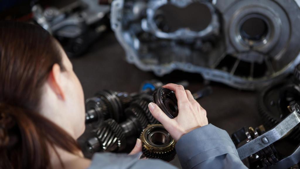 Una operaria manejando los engranajes de un motor de coche eléctrico
