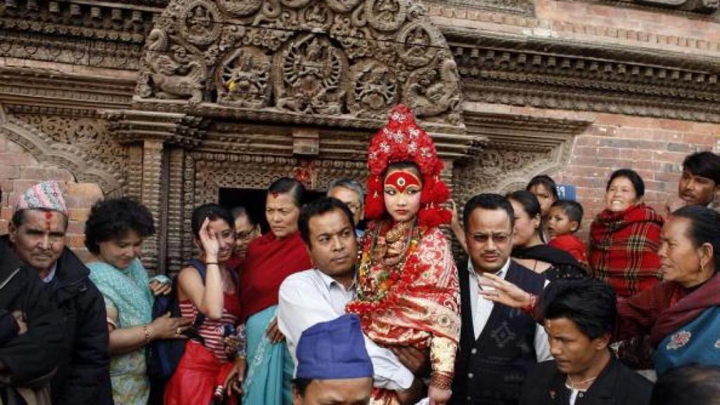 Kumari siendo llevada por un hombre ya que no puede tocar el suelo con sus pies.
