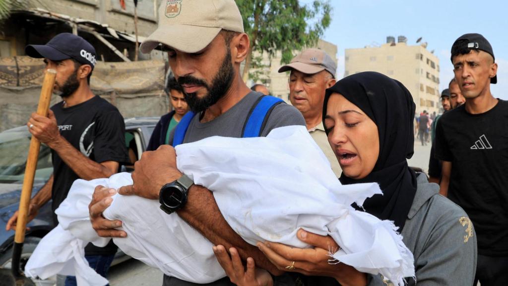 Un matrimonio lleva en brazos a su hijo muerto en un ataque de Israel en Jan Yunis, en Gaza.