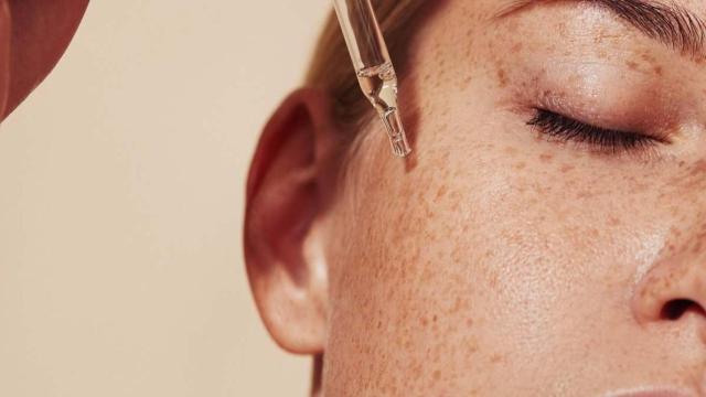 Una mujer se aplica retinol en el rostro.