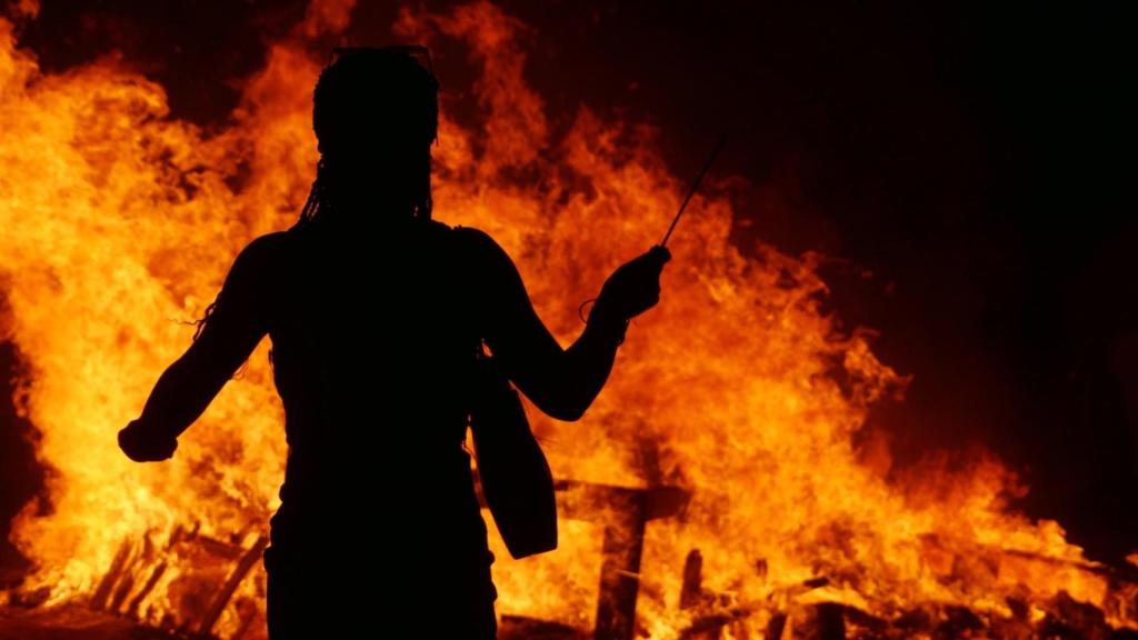 Una mujer frente a una hoguera de San Juan