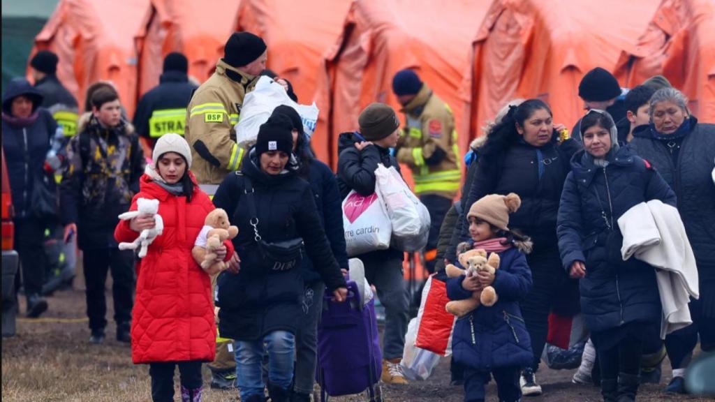 La gente pasa junto a tiendas de campaña en su camino a abordar un tren después de cruzar la frontera de Ucrania a Polonia, tras la invasión rusa de Ucrania, en el puesto de control fronterizo en Medyka, Polonia, el 9 de marzo de 2022.