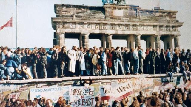 El 9 de noviembre de 1989 cae el Muro de Berlín y ciudadanos de Alemania Oriental (sobre el muro) saludan a sus vecinos de Alemania Occidental.