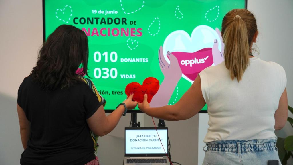 Dos mujeres con el contador de donaciones de sangre y salvamento de vidas.