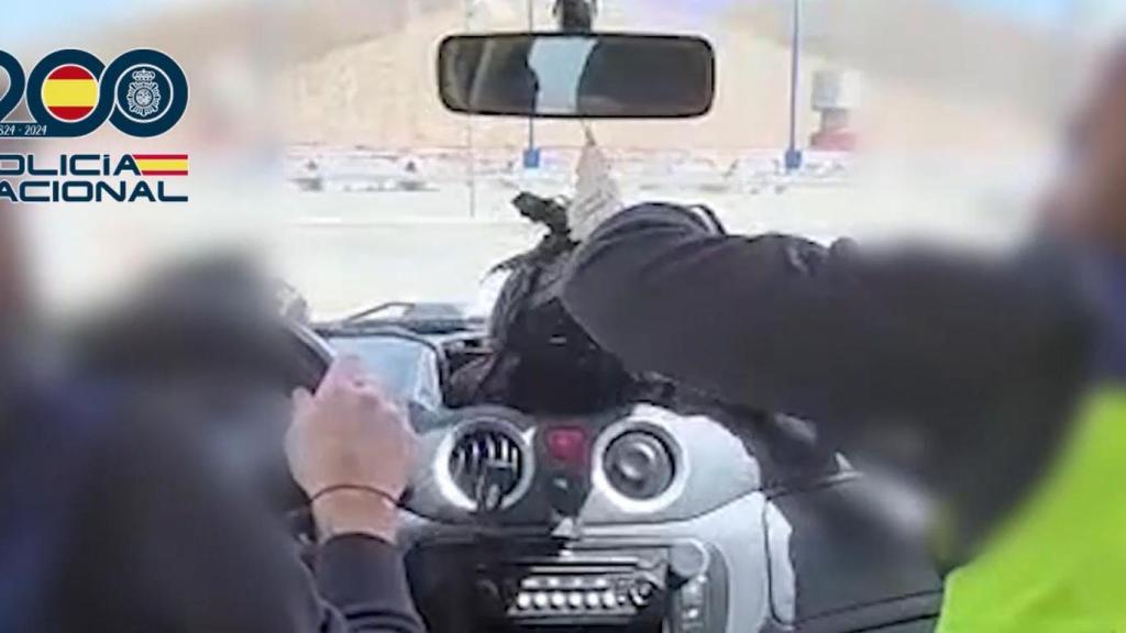 El momento en el que dos agentes de la Policía Nacional encuentran cocaína en un coche caleteado.