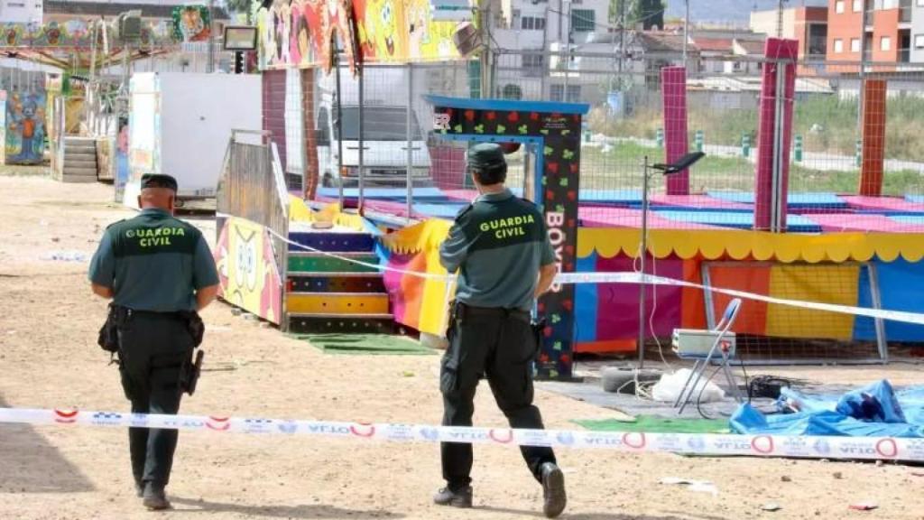 Dos agentes de la Guardia Civil precintando las camas elásticas del recinto ferial de Alquerías, tras la muerte de una niña, durante la madrugada del domingo.