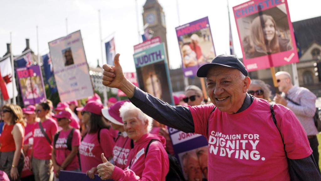 Defensores de la eutanasia sostienen pancartas durante las protestas a favor del proyecto de ley sobre la eutanasia, en la plaza del Parlamento en Londres.