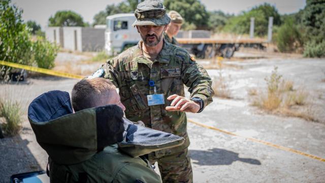 Uno de los soldados ucranianos reposa, exhausto, tras una de las prácticas con el traje de 40 kilos a pleno sol, ante las explicaciones de un mando español.