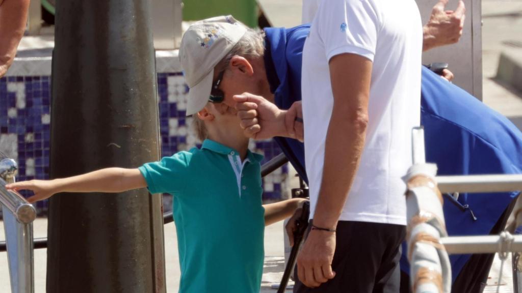 El rey Juan Carlos se agacha para recibir un beso de su ahijado y sobrino nieto Carlos, hijo de María Zurita.