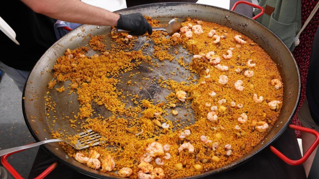 Una persona sirviendo una paella