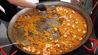 Una persona sirviendo una paella