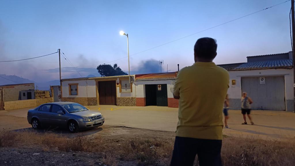 Paco, vecino de La Unión, observa su cochera, y tras esta, el humo del incendio que se ha destado en un solar contiguo.