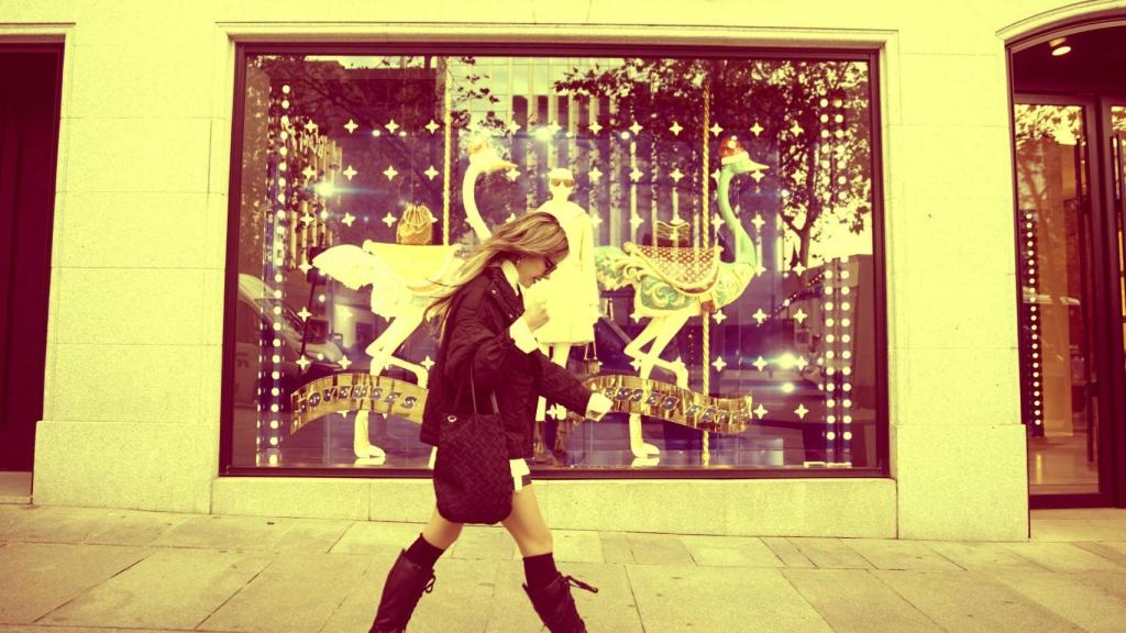 Una mujer camina frente a la tienda de Louis Vuitton
