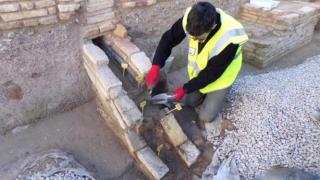 Un investigador toma muestras de las canalizaciones del yacimiento de San Esteban (Murcia) para enviarlas a analizar en laboratorio.