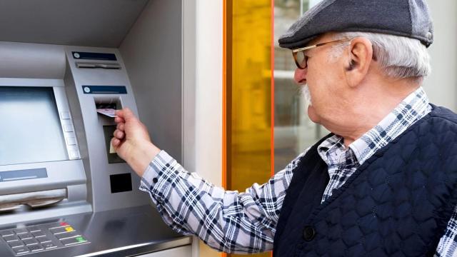 Un jubilado extrayendo dinero de un cajero, en imagen de archivo.