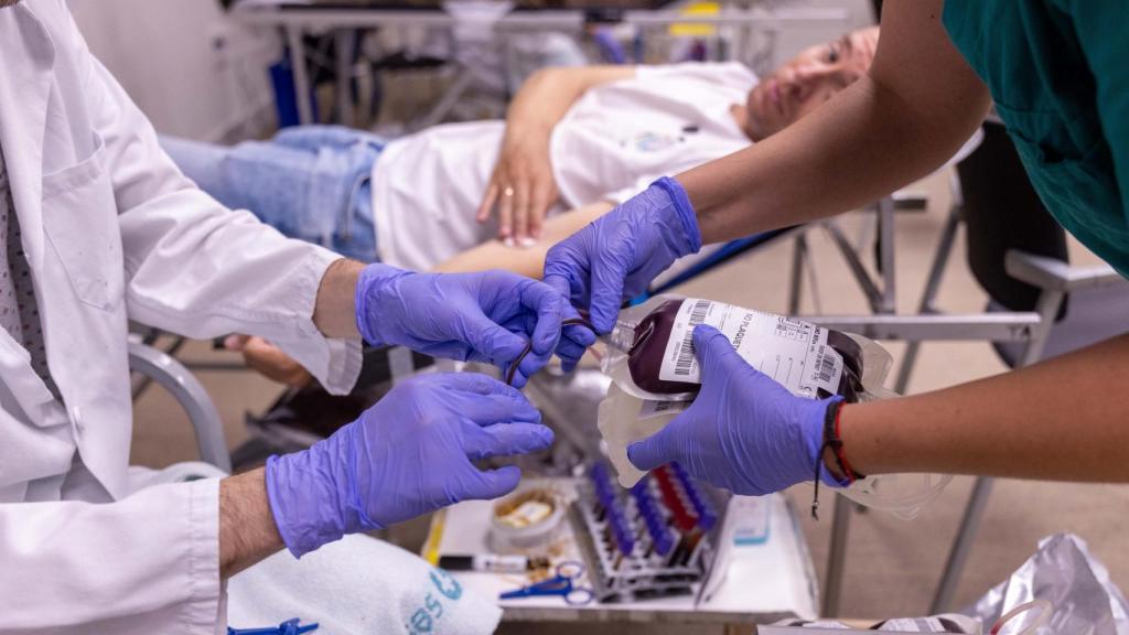 Dos profesionales enfermeros manipulando una bolsa de sangre.