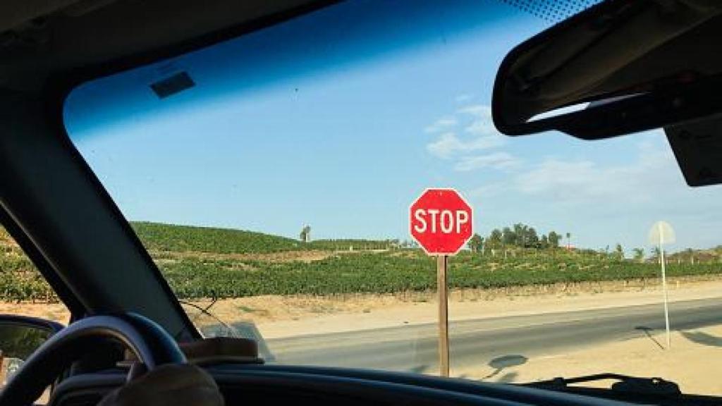 Imagen de un vehículo frente a una señal de Stop.