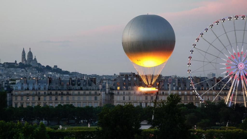 El pebetero de París 2024, con una llama 100 % eléctrica y no olímpica diseñada por Mathieu Lehanneur, flotó en un globo aerostático sobre el cielo de París durante la Fête de la Musique, el 21 de junio de 2025.