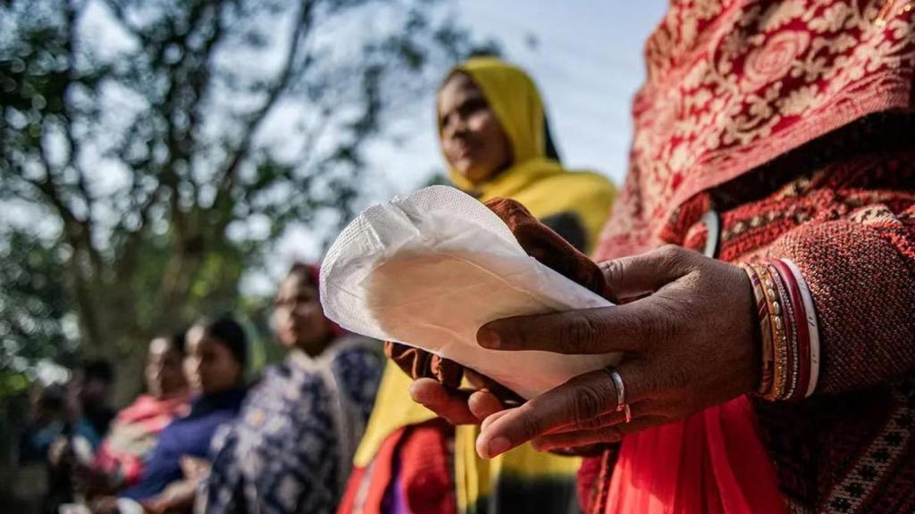 Varias mujeres sostienen productos menstruales durante una campaña de concienciación organizada por UNICEF en India, en 2022.