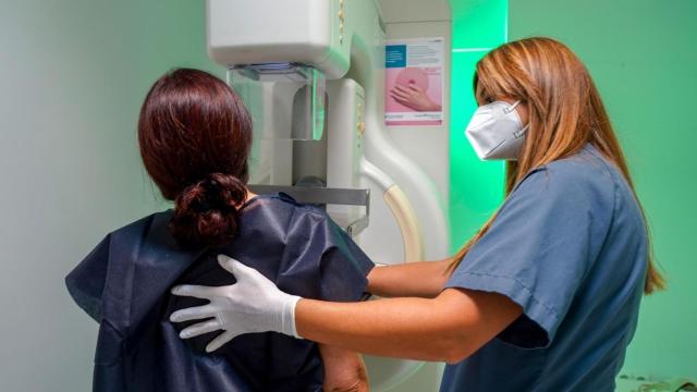 Una paciente haciéndose una mamografía con la ayuda de una enfermera.