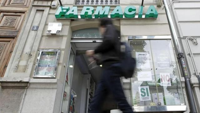Farmacia del centro de Valencia con carteles contra los impagos. Efe / Manuel Bruque