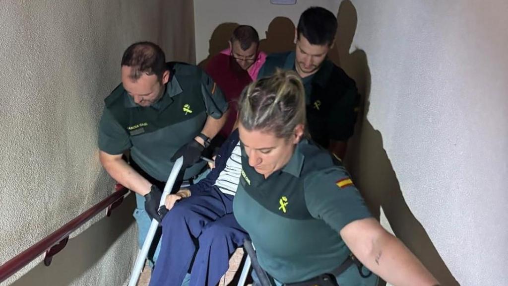 Los agentes de la Guardia Civil ayudando a subir a una de las personas mayores a su habitación