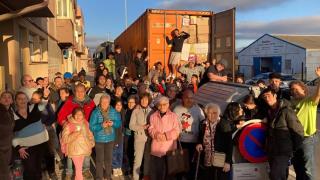 Responsables y voluntarios del Ropero de Puente Ladrillo junto a uno de sus contenedores de ropa