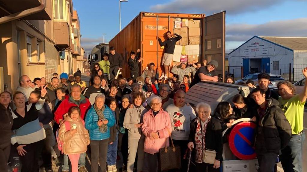 Responsables y voluntarios del Ropero de Puente Ladrillo junto a uno de sus contenedores de ropa