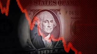 Un gráfico con tendencia bajista sobre un billete de dólar.