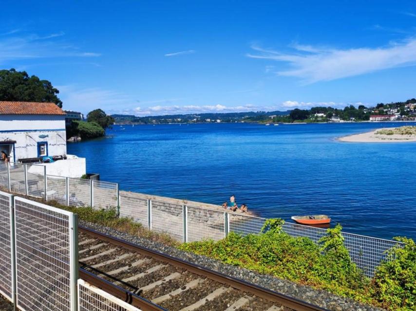 Bañistas entre la ría y las vías del tren en As Xubias de Abaixo.