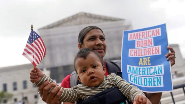 Una mujer con su hijo ante el Tribunal Supremo de Estados Unidos con un cartel que dice: Los niños nacidos en Estados Unidos son niños estadounidenses.