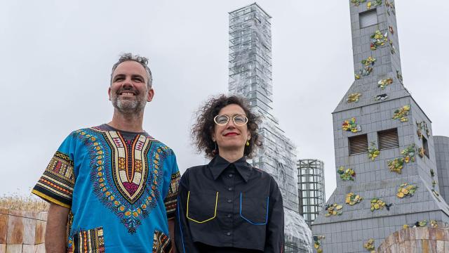 Rubén Lorenzo y Mónica Gutiérrez, de Basurama, delante de las torres Hedjuk de la Ciudad de la Cultura de Santiago de Compostela, cubiertas con su intervención 'Plastic Biontes'. Foto: Manuel G. Vicente