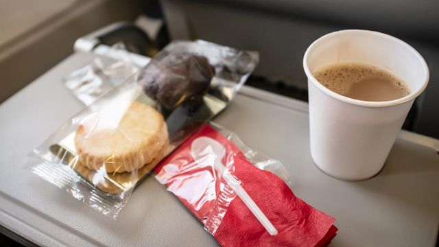 Unas galletas y un café en la mesilla desplegada de un avión