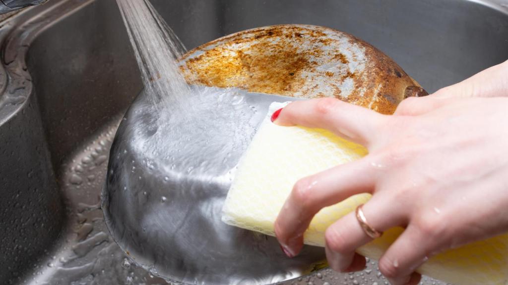 Una persona friega una sartén de acero