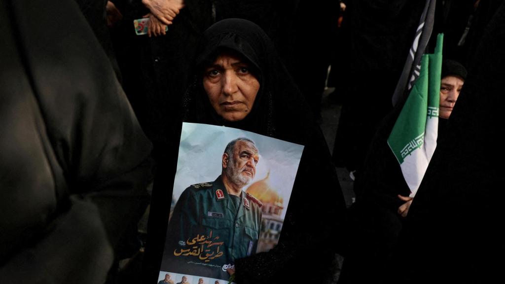 Una mujer sostiene una fotografía del difunto comandante en jefe del Cuerpo de la Guardia Revolucionaria Islámica (CGRI), mayor general Hossein Salami, mientras asiste a la procesión fúnebre de los comandantes militares y científicos nucleares iraníes muertos en los ataques israelíes, en Teherán, Irán , el 28 de junio de 2025.