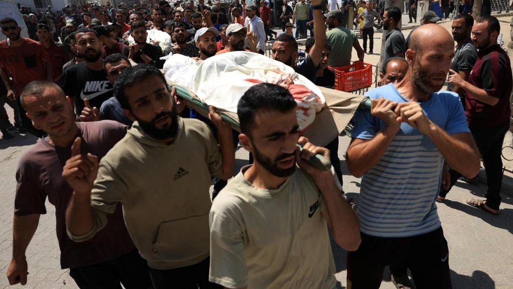 Un grupo de palestinos lleva el cadáver de un joven muerto en un ataque israelí en Gaza.