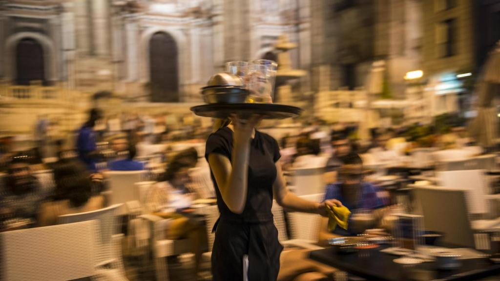 Una camarera atendiendo mesas.