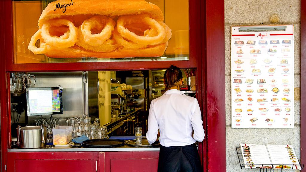Una camarera en la entrada de un bar.