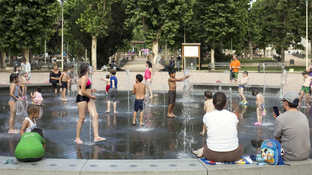 Un grupo de personas refrescándose en una fuente en Salamanca
