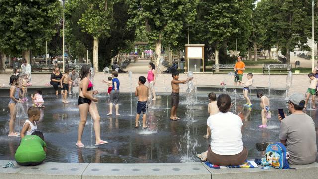 Un grupo de personas refrescándose en una fuente en Salamanca