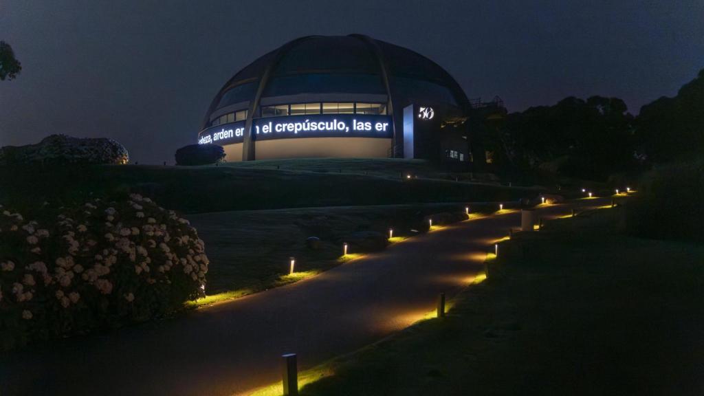 El lugar de la exposición iluminado durante la noche.
