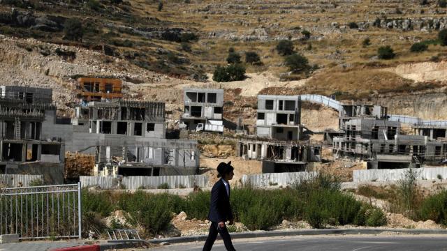 Un colono judío pasa junto a obras de construcción de asentamientos israelíes en los alrededores de Givat Zeev y Ramat Givat Zeev, en la Cisjordania ocupada por Israel, cerca de Jerusalén, el 30 de junio de 2020.