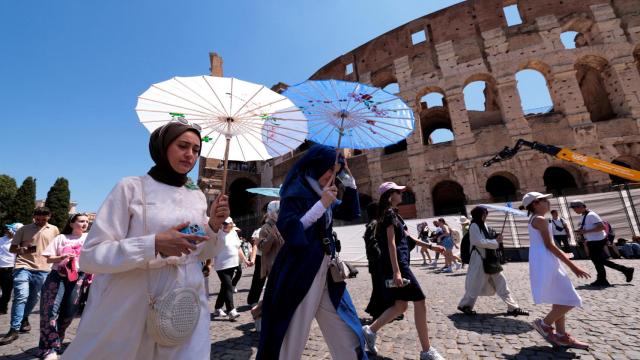 Turistas caminan este lunes frente al Coliseo en plena ola de calor en Roma.