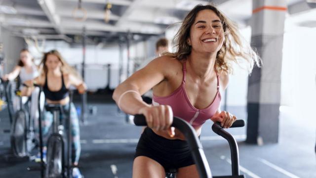 Imagen de archivo de una mujer haciendo ejercicio en una bicicleta estática.